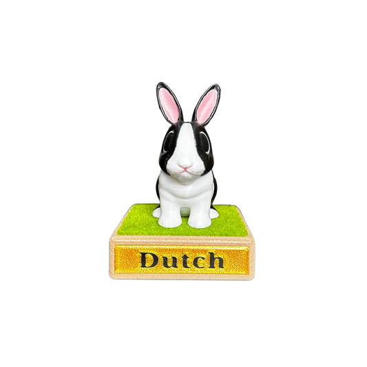 Small black and white rabbit figurine on a wooden base with 'Dutch' text